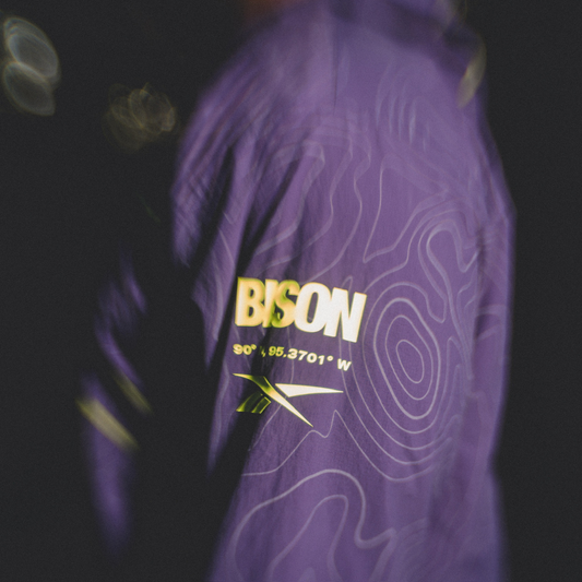 REEBOK APPAREL UNISEX Reebok x A Herd of Bison Packable Jacket MOVEMENT PURPLE/BLACK/DIGITAL LIME